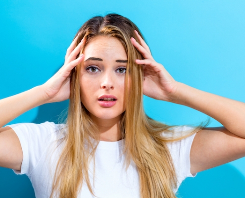 Young woman feeling stressed on a blue background