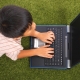 Young Kid Using His Notebook Computer For Study And Fun